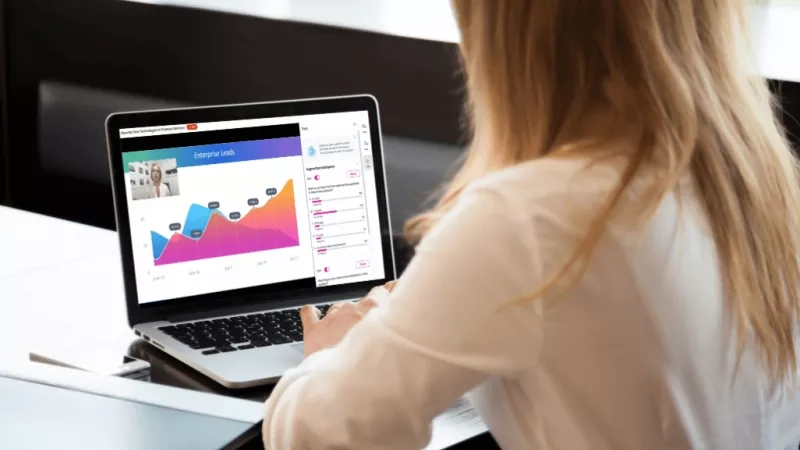 A woman is looking at a chart on a laptop screen.