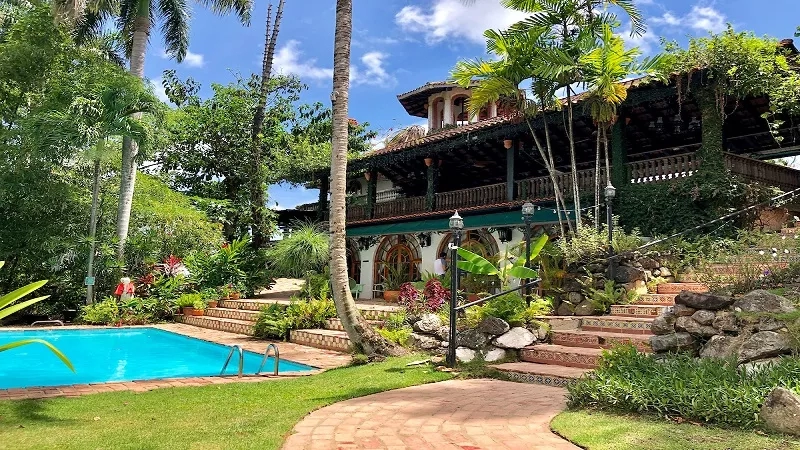 The Casa de Siesta Alegre is surrounded by lush landscaping, with a pool and tropical ambiance.