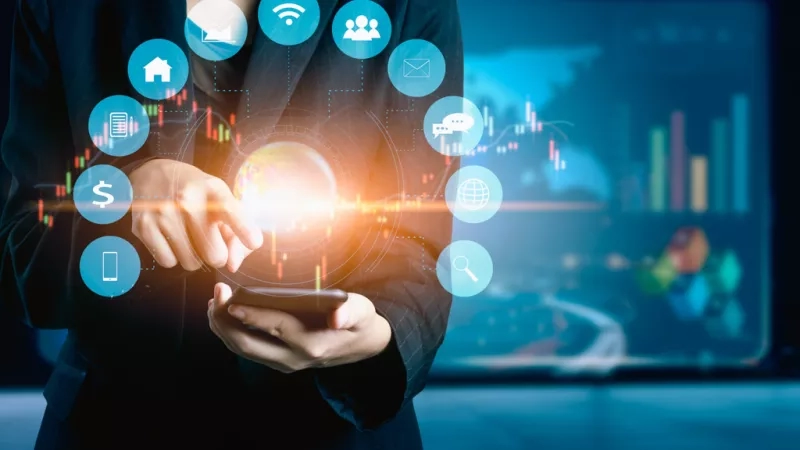 A woman in a suit is holding a phone with a glowing globe in the center.