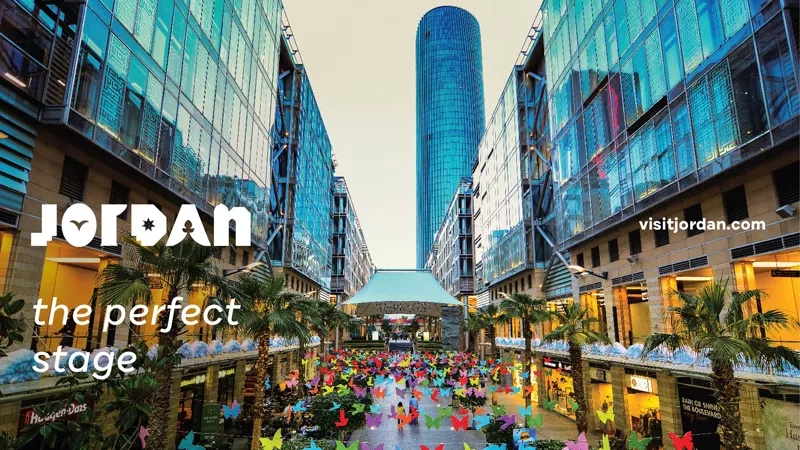 Jordan's cityscape with buildings, butterflies, and text "Jordan: The Perfect Stage" on the left.