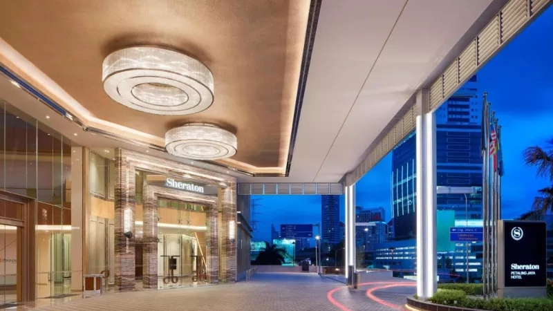 A picture of the entrance to the Sheraton Petaling Jaya Hotel at night, with buildings in the background.