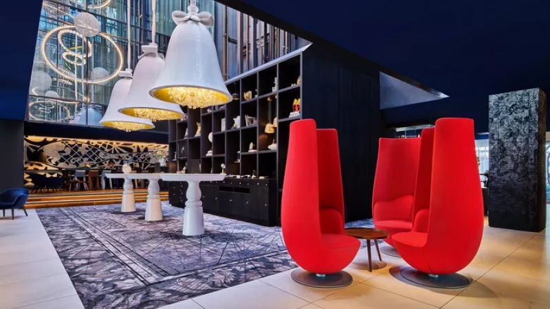 The Hyatt Centric Grand Place lobby with black and white interior design, blue ceiling, and red chairs.