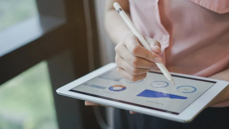 Hotel manager analyzing business intelligence data on tablet in her hands.