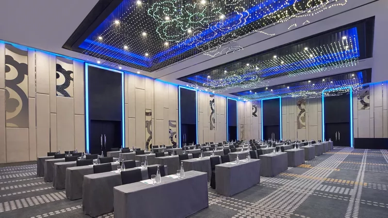 Meeting room with round tables and a high ceiling with lights at Mandarin Oriental, Kuala Lumpur.