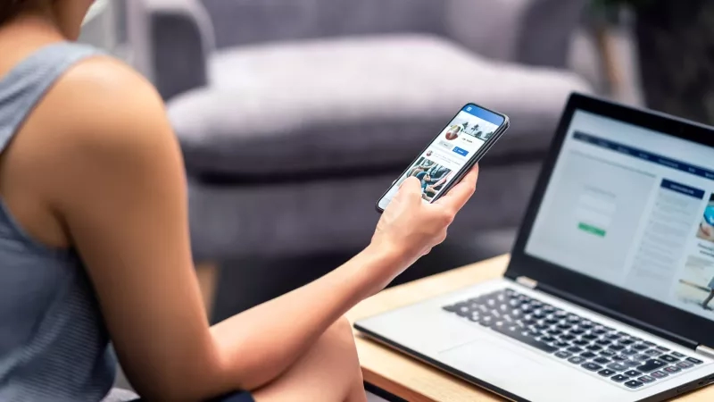 Hotel employee using social media on phone to increase hotel bookings.