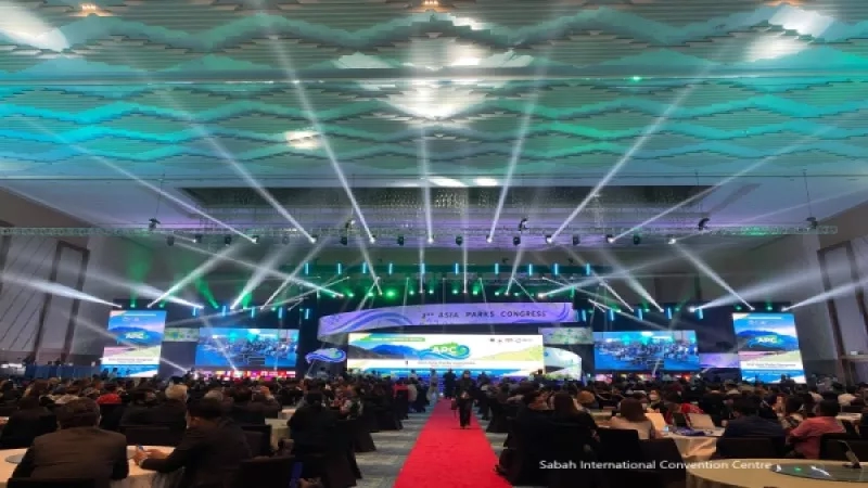 Sabah International Convention Centre, featuring a large audience in a grand hall with vibrant lighting and a red carpet.