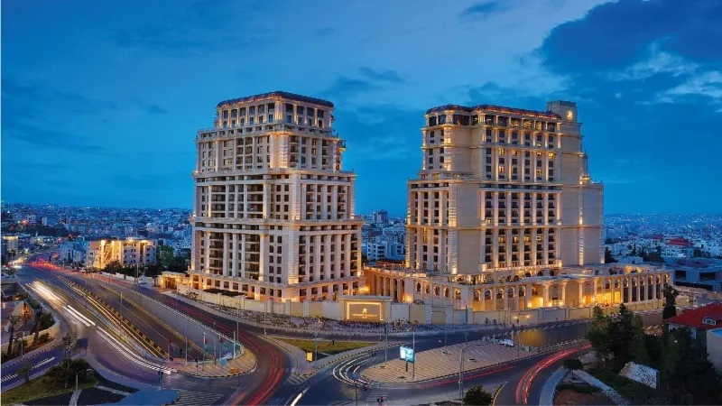 A beautiful view of the Jordan hotel with a cityscape and lightings in the middle of the city.