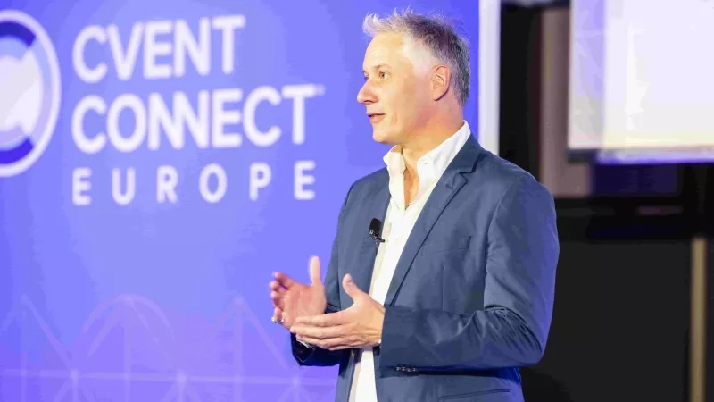 A man in a suit is giving a presentation on stage at Cvent Connect Europe 2024.