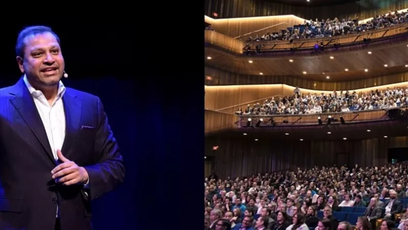 Raj Shah speaking on stage in front of a large audience at the Winspear Centre.