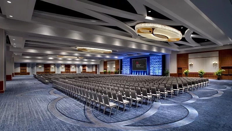 The Bosco Ballroom is a large conference room with chairs, a stage, and a screen.