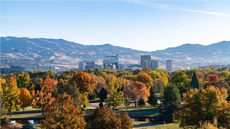 Mountain view with cityscape and autumn trees in the foreground for the month of April.