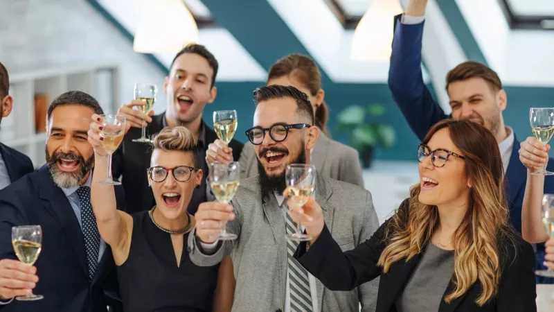 Group of people having fun at a conference and toasting with wine glasses.