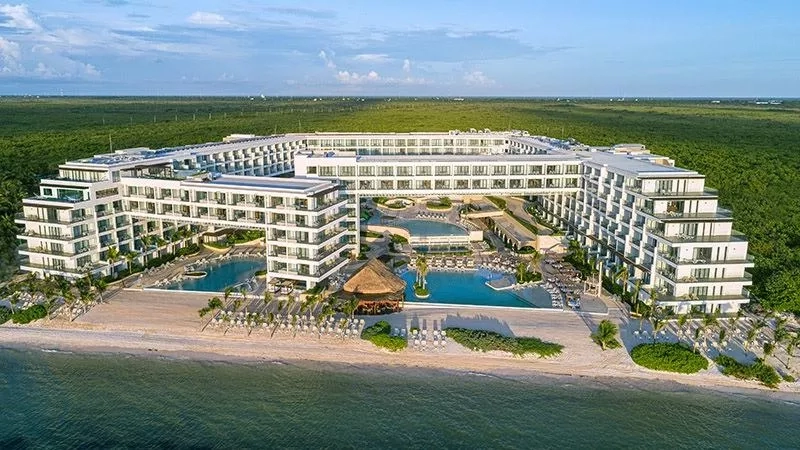 Aerial view of Sensira Resort & Spa Riviera Maya with pools and beach in the foreground.