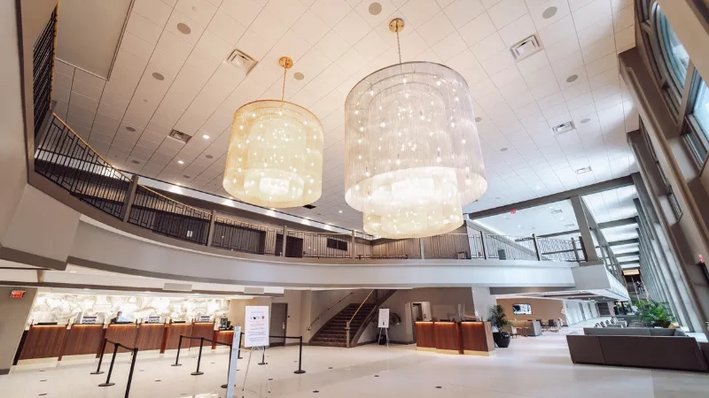 Two chandeliers hang from the ceiling in the lobby of the Renaissance Columbus Downtown Hotel.