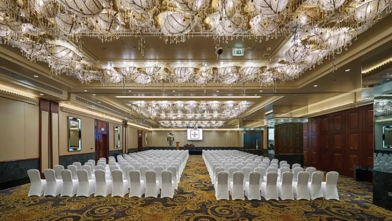 Ballroom with rows of chairs and ornate chandeliers at The Westin Palace, Milan.