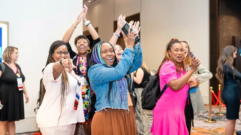 A group of women at Younger Generation Events having fun and dancing with each other.