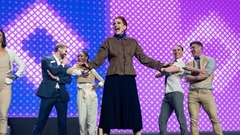 A group of six people on stage, in front of a purple background, at Cvent CONNECT 2023.