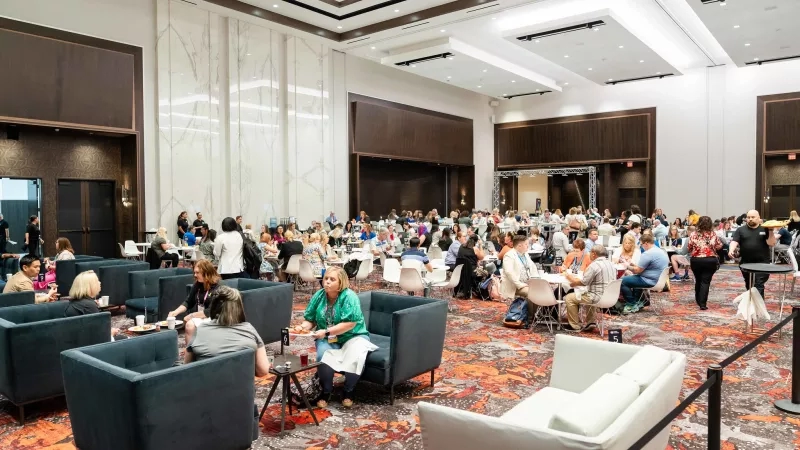 Conference room full of people eating lunch and chatting with each other at the PULSE Conference.