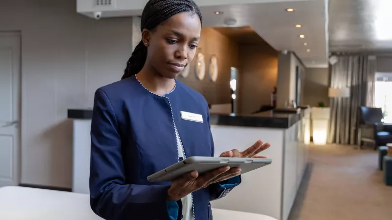 Receptionist using a tablet in the reception area of the hotel