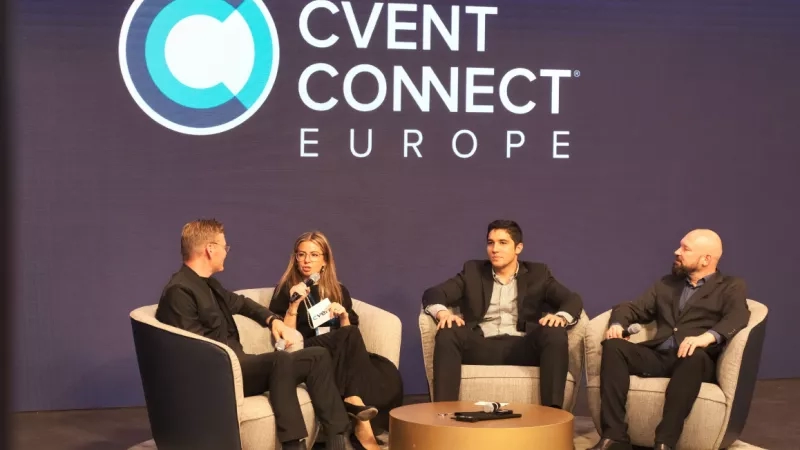Four people sitting on chairs with a "Cvent Connect Europe" sign behind them.