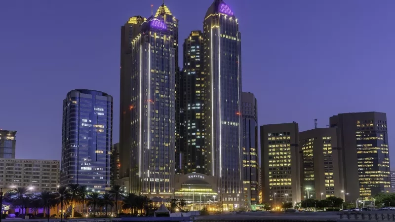 The Sofitel Abu Dhabi Corniche Hotel with two twin towers in blue and a canal in front.