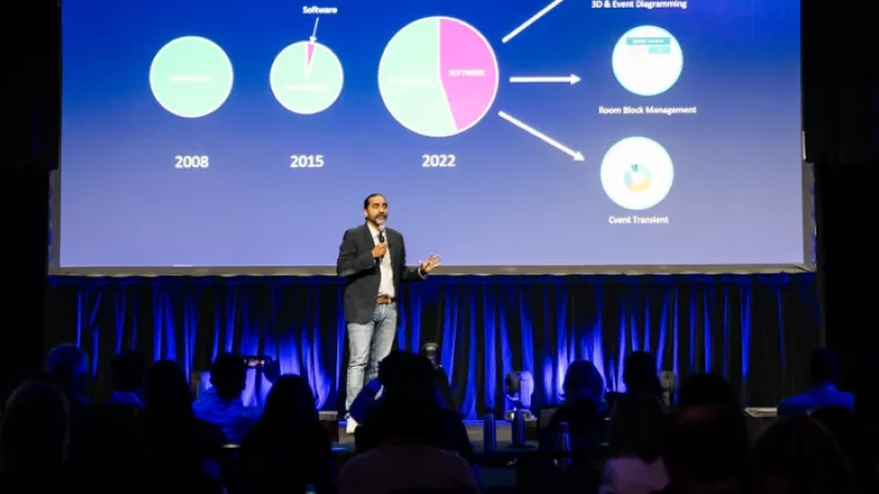 A man standing on a stage talking about the evolution of the business model.