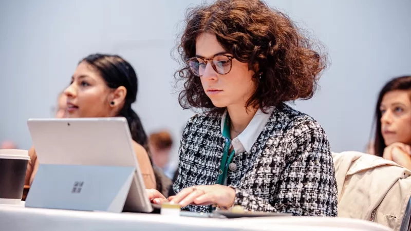 A woman is working on her laptop while attending an event at the Microsoft Corporate Headquarters.