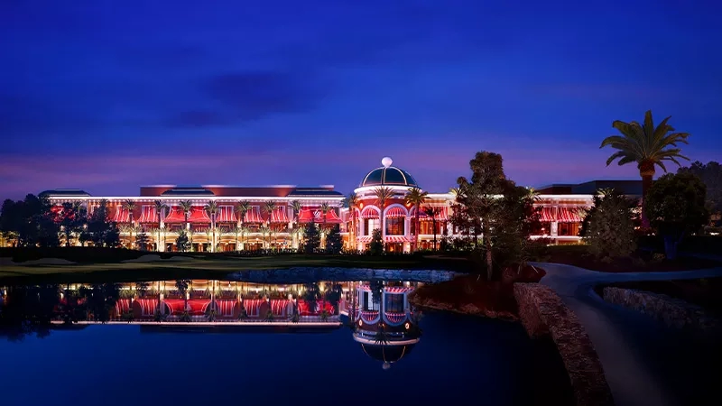 Wynn Meetings and Conventions promo exterior night image with dome and reflection in water, trees, and pathway.