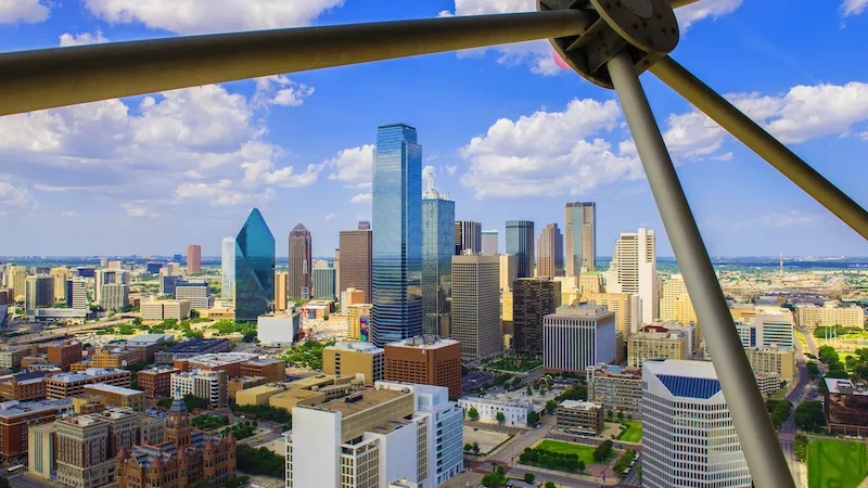 A top-down view of the Dallas skyline, showing the Reunion Tower and other skyscrapers.