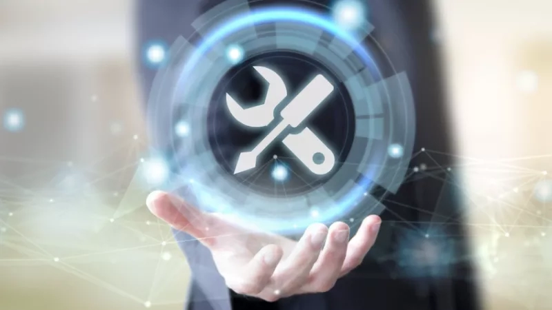 A person is holding a blue circle with a wrench and screwdriver on it.