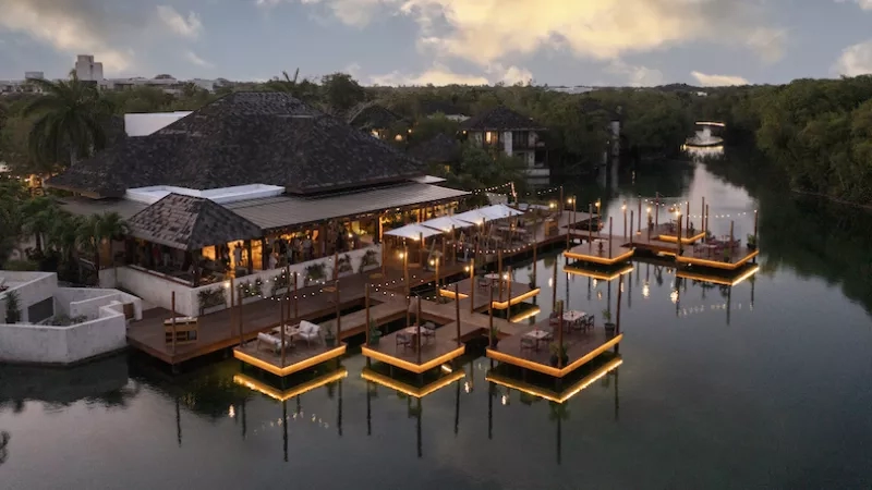 Aerial view of La Laguna at Mystique Holbox by Royalton with floating docks and river at night.