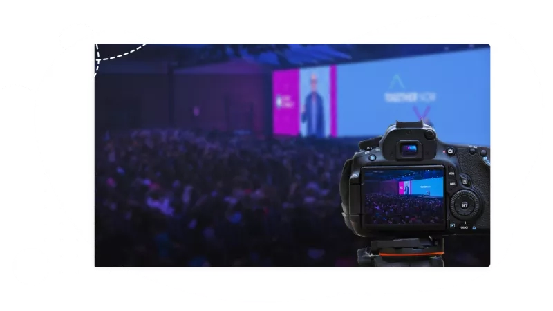 A camera is capturing an event with a crowd of people.