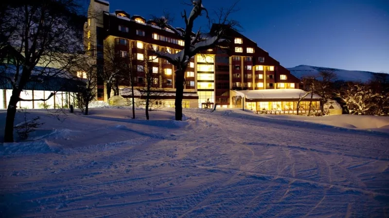 Night view of Hotel del Bosque, a large resort in Chile with snow covering the ground.