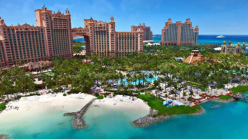 Aerial view of Atlantis resort with hotels, pools, beach, and ocean in the background.