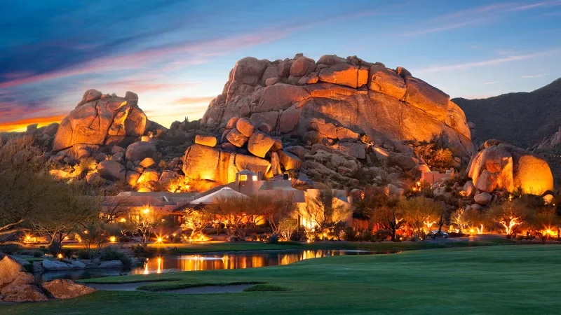 A stunning sunset view of the Boulders Resort and Spa, featuring its architecture, landscaping, and ambiance.
