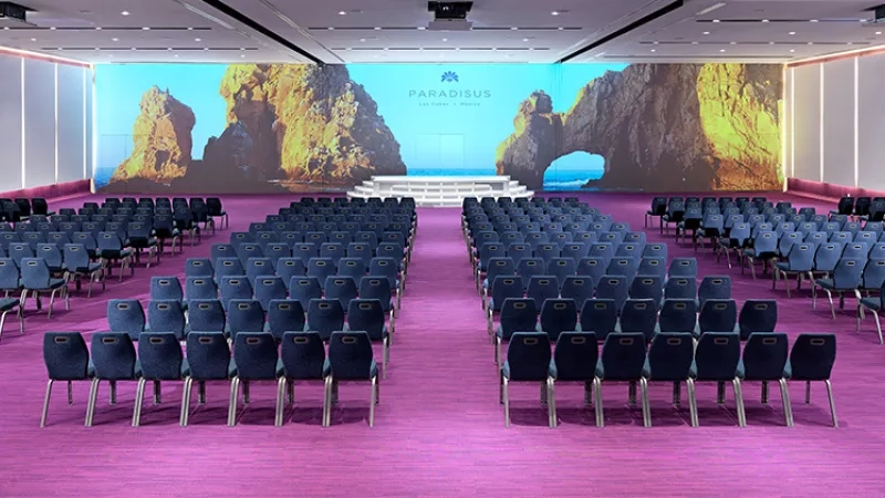 Meeting room with a large screen and many chairs arranged in rows at Paradisus Grand Cana.