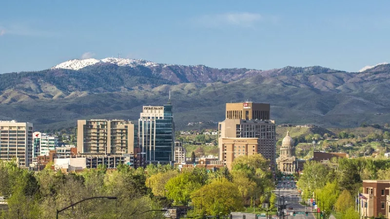 Boise city view with mountains in the background and buildings of different sizes in the foreground.