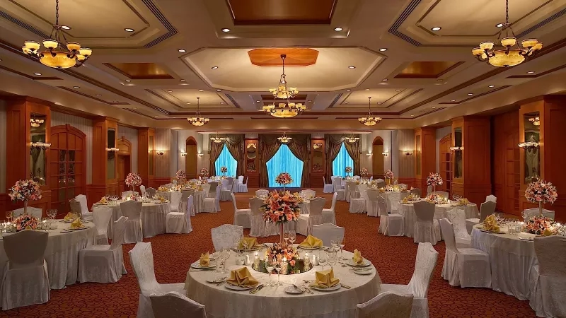 A banquet hall at Carlton Palace Hotel Dubai with several tables set up for an event.