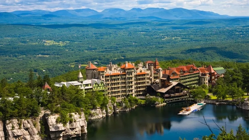 A beautiful view of the lake with a boat on the surface and a large castle nearby.