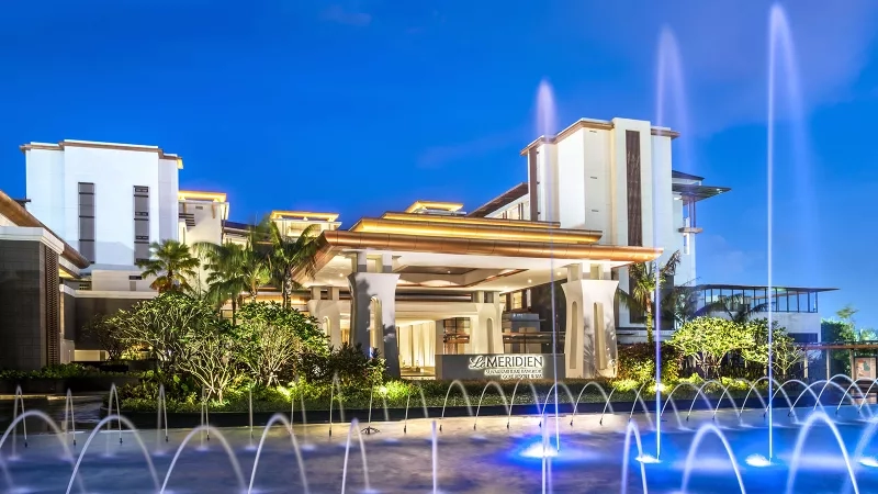 Le Meridien Suvarnabhumi Bangkok Golf Resort & Spa hotel entrance with illuminated fountains at night in Thailand.