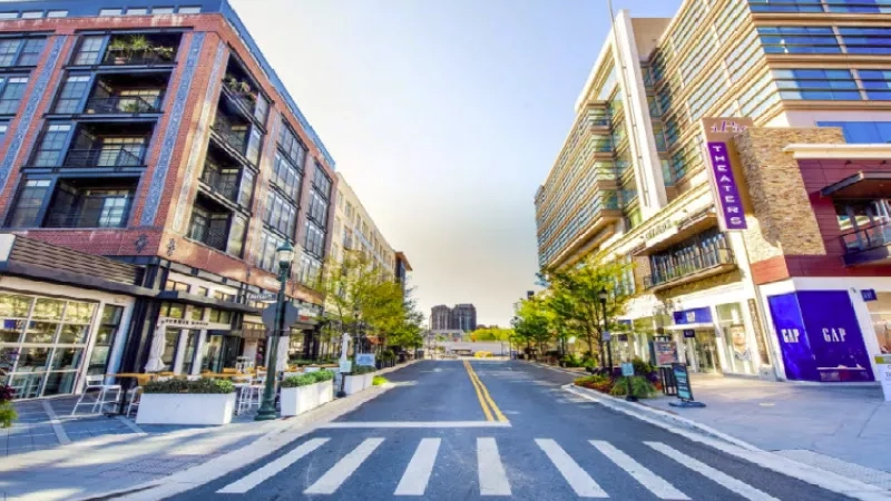 A serene urban streetscape with buildings, lush landscaping, and a pedestrian-friendly atmosphere.
