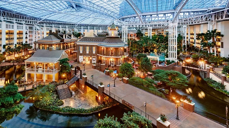 Gaylord Opryland Resort & Convention Center features an atrium with a glass roof, buildings, and a water feature.