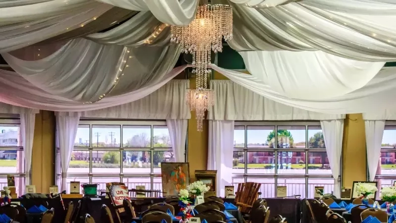 Banquet hall at The Resort in Granbury, Texas, with white draping and chandeliers.