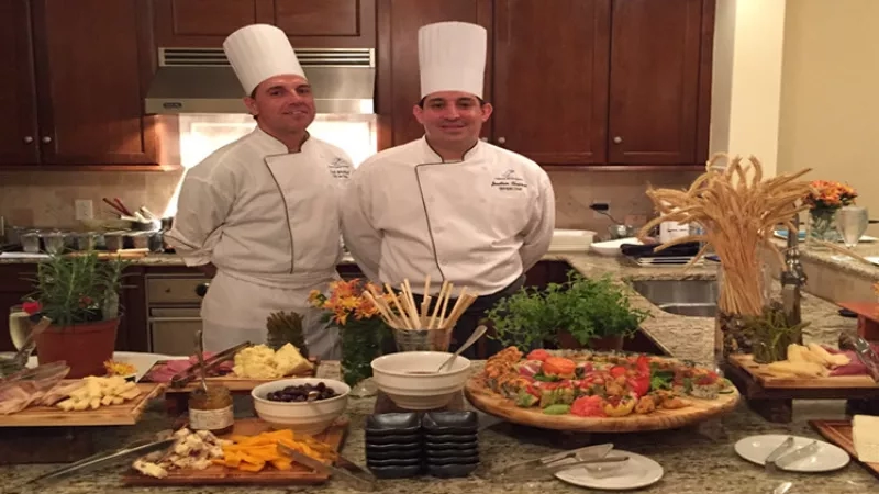 Two chefs stand behind a buffet table of food at the Hammock Beach Resort in Palm Coast, Florida.