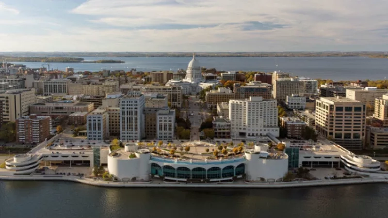 Madison, Wisconsin, aerial view with Monona Terrace and Capitol building, showing urban architecture and scenic water.