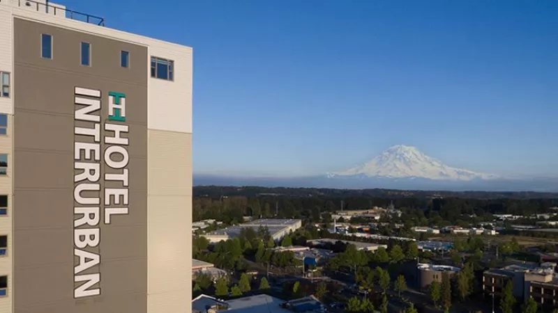 Interurban Hotel in Tacoma, Washington, with Mount Rainier in the distance under a clear sky.