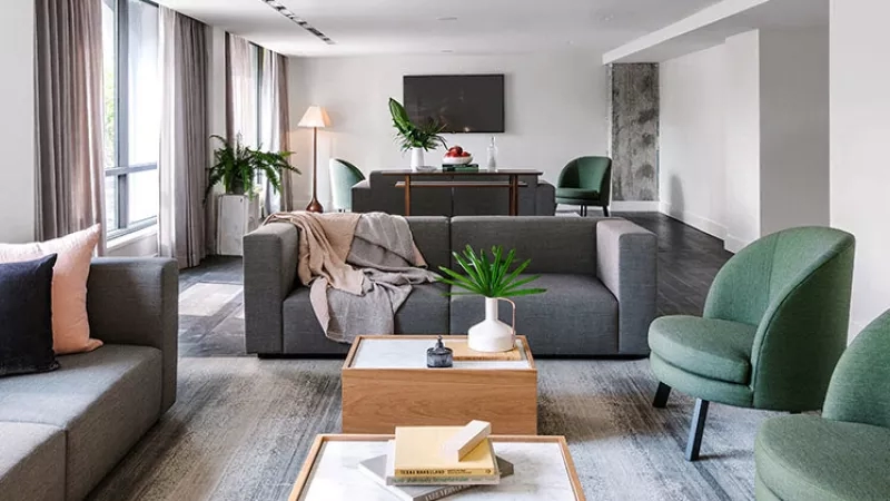 The living room in LINE Austin is furnished with a couch, chair, and a center table.