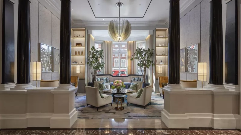 The grand lobby of Mandarin Oriental Hyde Park, London with a large table and chairs.