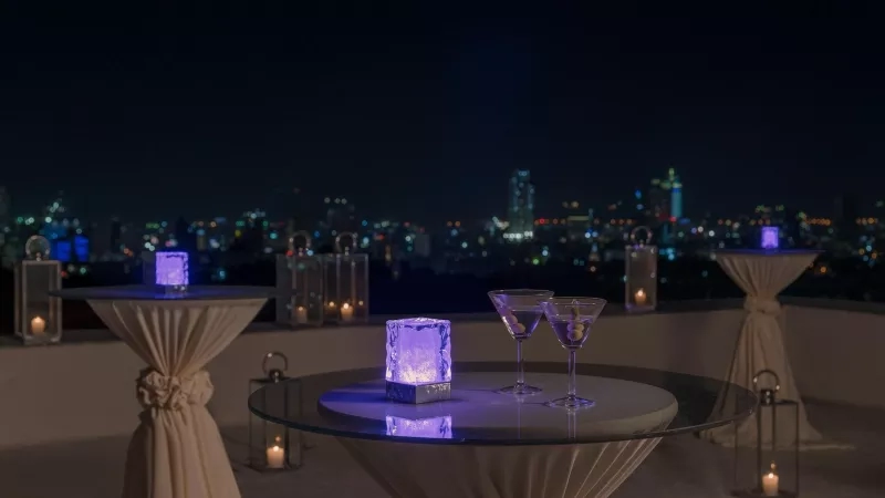 Elegant event setup at Marco Polo Plaza Cebu with LED ice cubes and martini glasses, city skyline view at night.