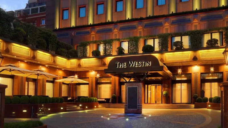 The Westin exterior with landscaping and architecture in an urban setting with text, lighting, and ambiance.